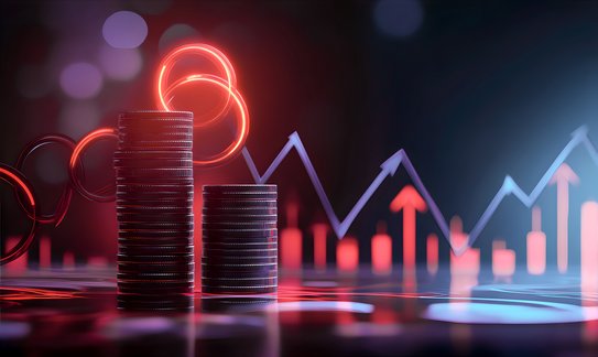 Zwei aufgetürmte Stapel mit Geld im Hintergrund eine Grafik eines Diagrammes