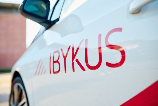 Abbildung der IBYKUS Word-Bild-Marke auf einem Dienstwagen.