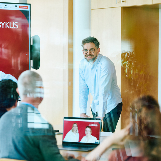 Geschäftsmeeting mit Hybrid-Präsentation vor Ort und per Video-Konferenz.