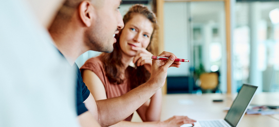 Mitarbeitende unterhalten sich angeregt in einer Meetingsituation