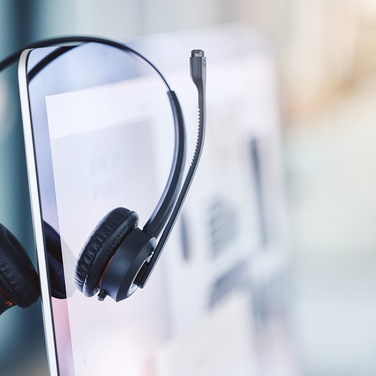 Ein Headset hängt seitlich auf einem Desktopbildschirm