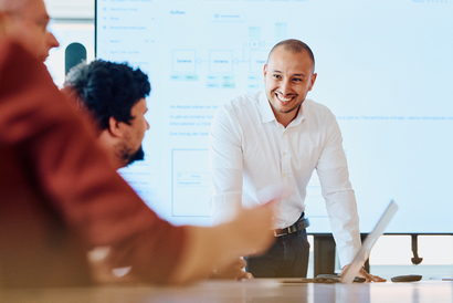 Drei Personen unterhalten sich in einer Meetingsituation