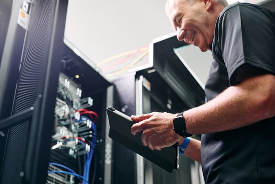 Ein Mitarbeiter bei der Wartung einer IT-Infrastruktur.