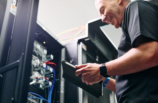 Ein Mitarbeiter bei der Wartung einer IT-Infrastruktur.