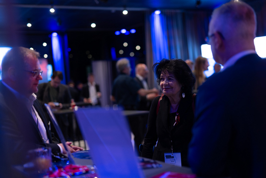 Impressionen der FutureHUB in Wien, Mitarbeitende unterhalten sich mit einer Besucherin am Stand