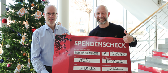 IBYKUS-Vorstand Michael Erdmann übergibt Sven Sauer den Spendenscheck in Höhe von 2500€.