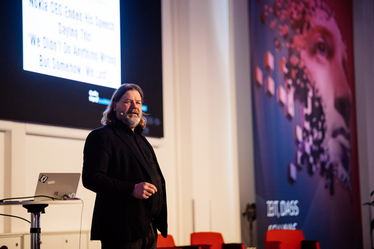 Ein Mann hält auf der Bühne einen Vortrag.