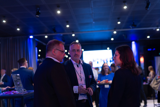 Impressionen der FutureHUB in Wien, Mitarbeitende unterhalten sich mit einer Besucherin am Stand