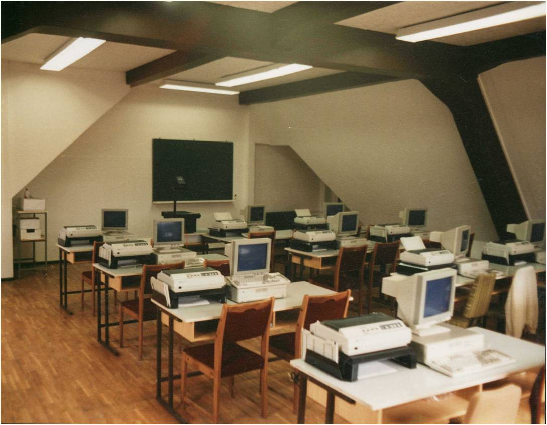 Ein Raum im Dachgeschoss mit sehr alten Computern mit Röhrendisplays auf Tischen aus Holz